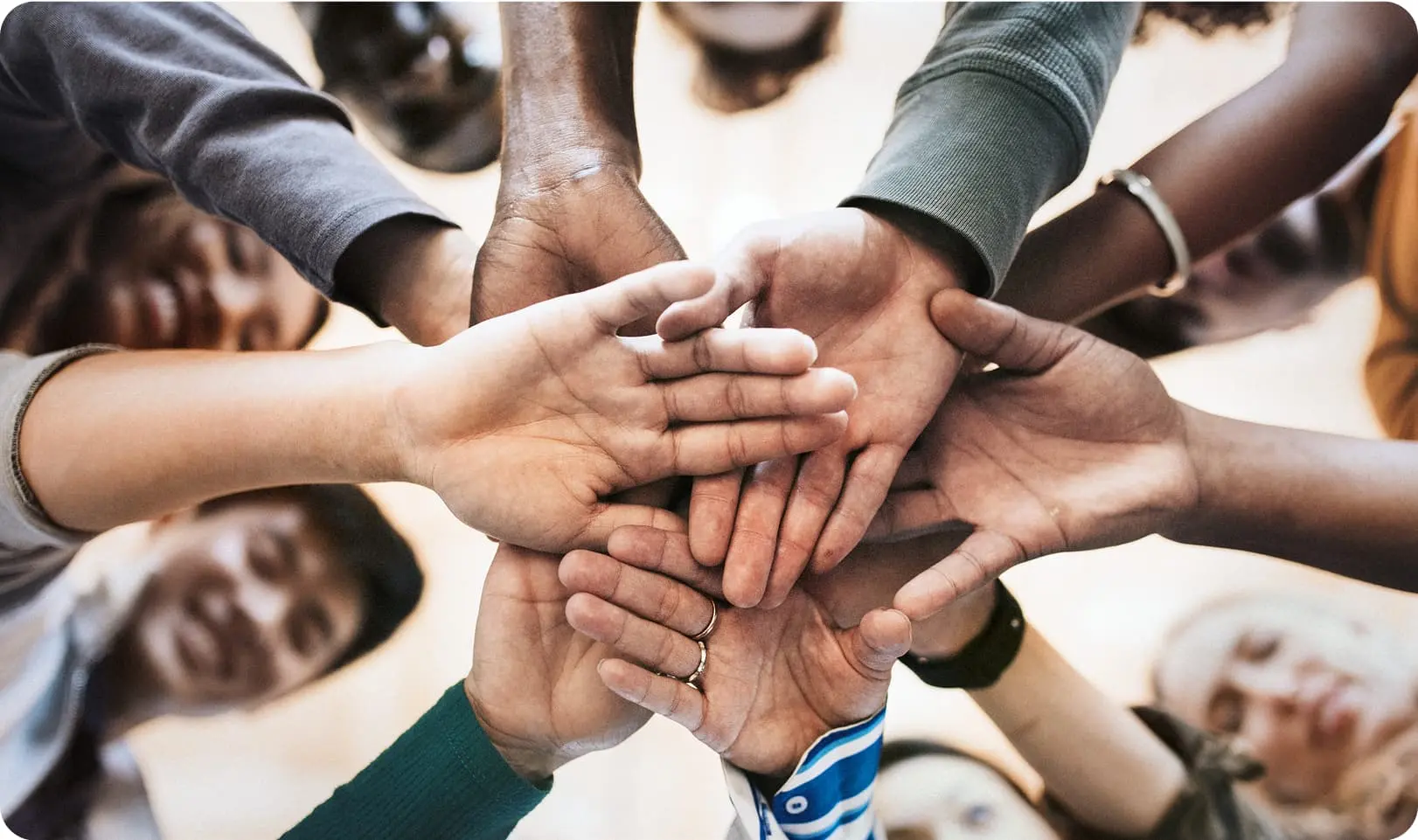 Groupe de personnes joignant leurs mains, symbolisant l'engagement solidaire d'Infiniwave avec Share The Meal